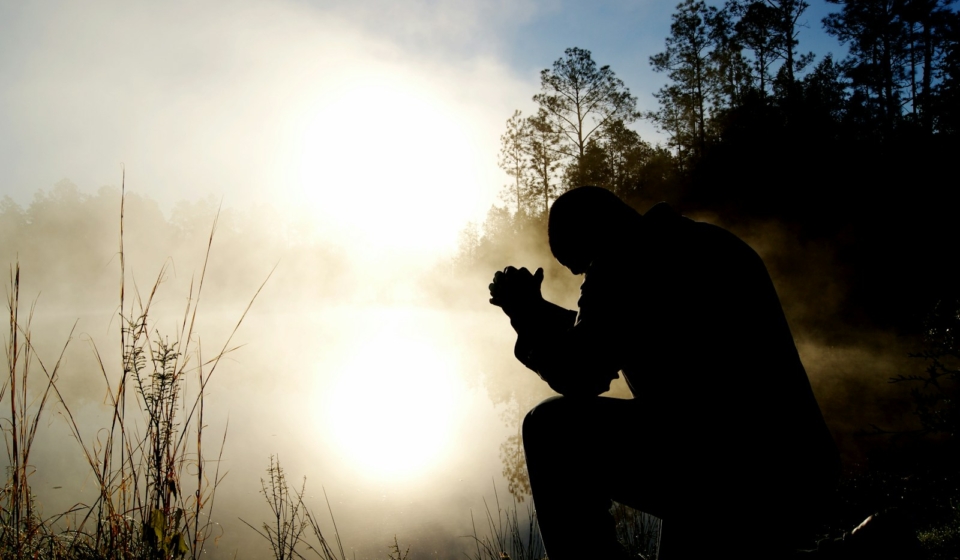 silhouette of kneeling man